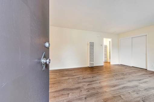 A room with a grey door and wooden flooring.