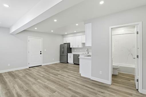 A kitchen with white cabinets and a refrigerator.