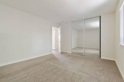 A room with a carpeted floor and a glass door.