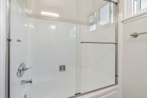A white bathroom with a glass shower door.