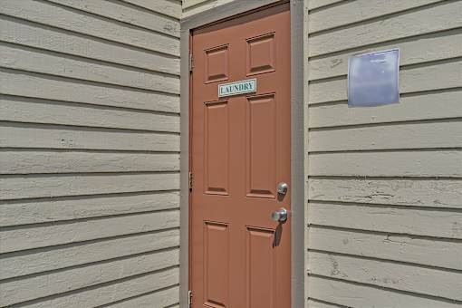 A brown door with a silver handle and a sign above it that says