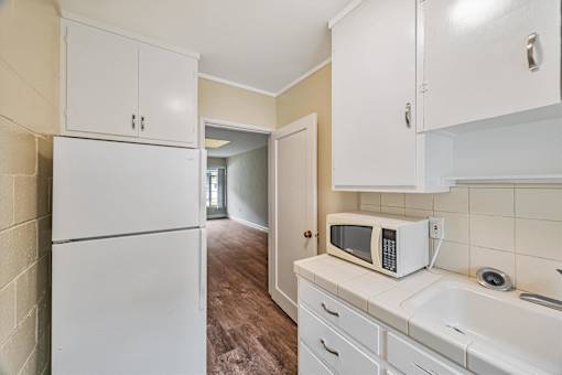 A kitchen with white appliances and cabinets.