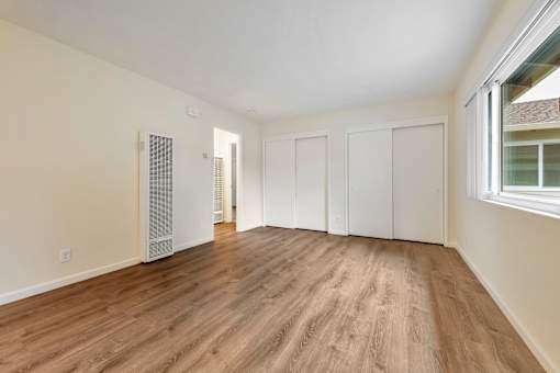A room with wooden flooring and white walls.