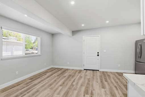 A room with a white door and a window with blinds.