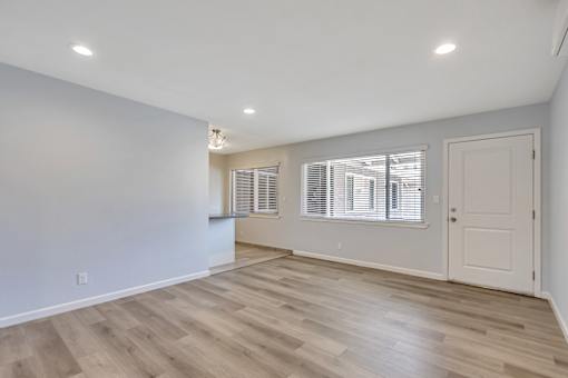 A room with wooden flooring and white walls.