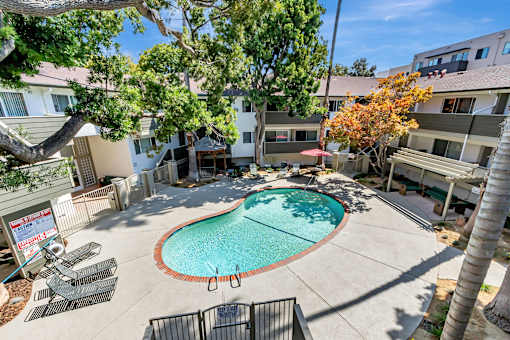 A pool surrounded by a fence and trees.