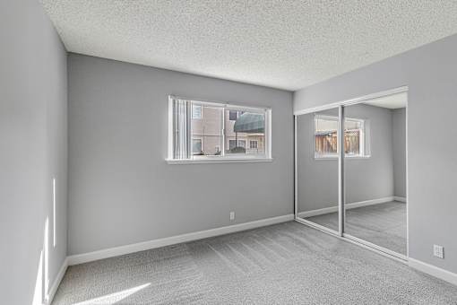 A room with a carpeted floor and a large window.