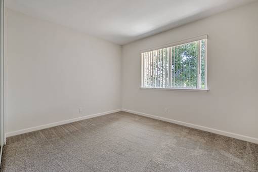 A room with a window covered by blinds.