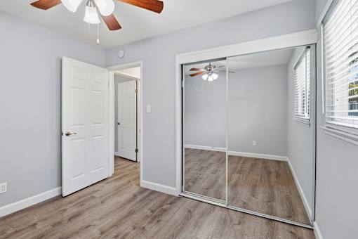 A room with a white door and a mirror on the wall.