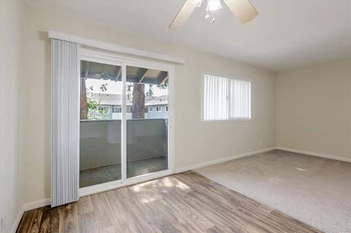 A room with a sliding glass door and a ceiling fan.