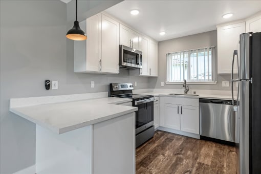 a kitchen with white cabinets and stainless steel appliances