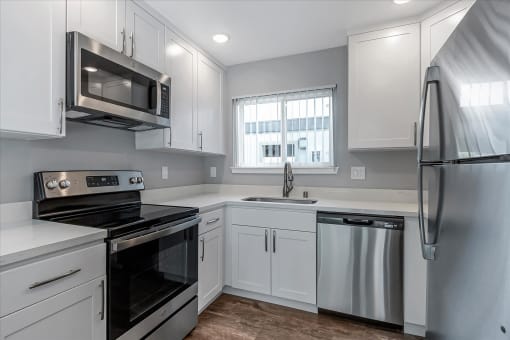 a kitchen with white cabinets and stainless steel appliances