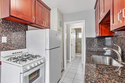 A kitchen with a white stove and a white refrigerator.