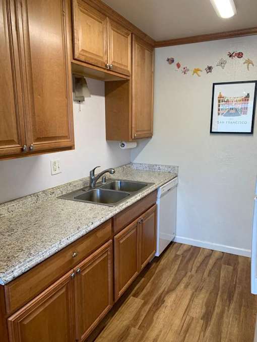 a kitchen with a stainless steel sink and wooden cabinets