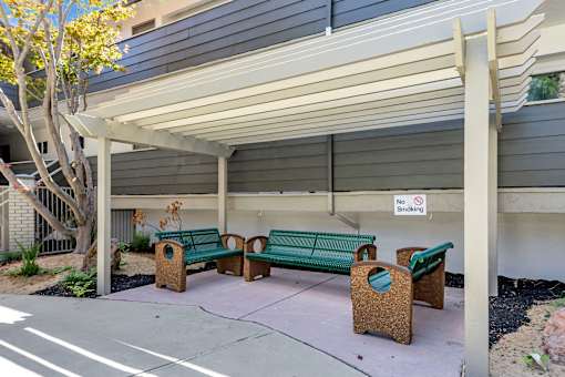 A small covered seating area with a no smoking sign.