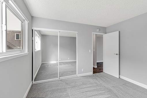 A room with a carpeted floor and a sliding glass door.
