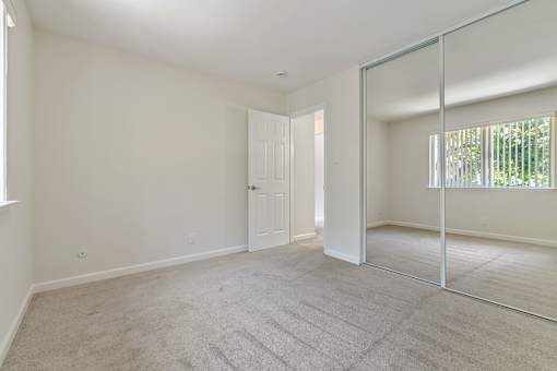 A room with a carpeted floor and a white door.