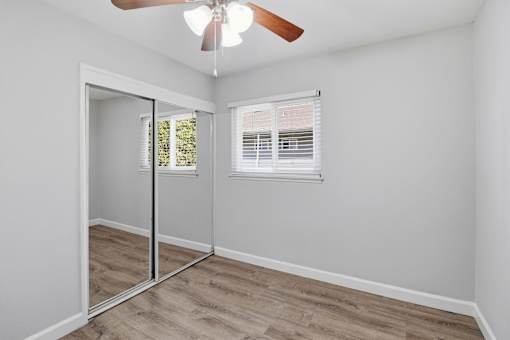 A room with a ceiling fan and a sliding glass door.