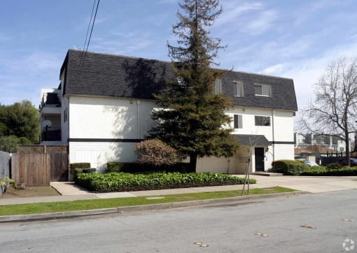 a white house with a gray roof on a street