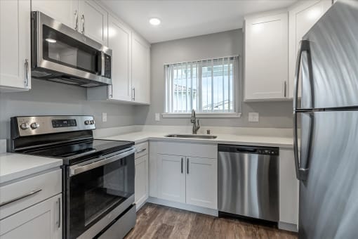 a kitchen with white cabinets and stainless steel appliances