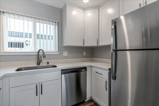 a kitchen with white cabinets and a stainless steel refrigerator
