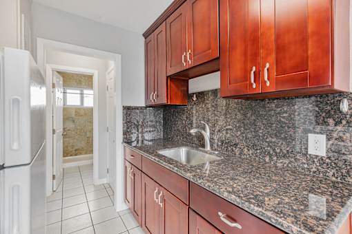 A kitchen with brown cabinets and a granite countertop.