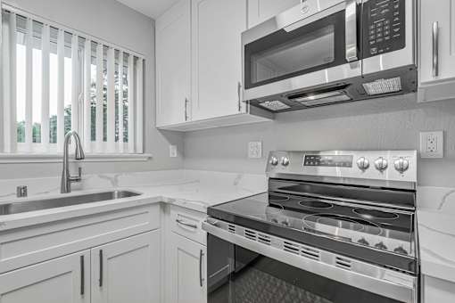 A modern kitchen with a stainless steel oven and microwave.