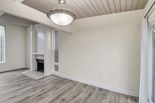 A room with a fireplace and wood flooring.