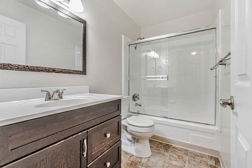 A bathroom with a white sink, a toilet, and a walk-in shower.