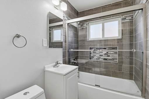 A bathroom with a toilet, sink, and tub.