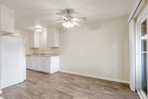A kitchen with white cabinets and a white refrigerator.