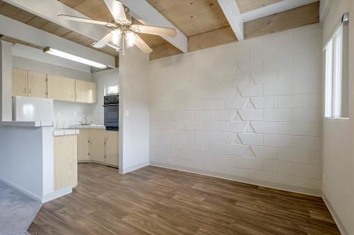 A room with a ceiling fan and wooden floors.