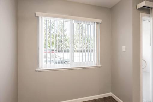 A room with a window and a white door.
