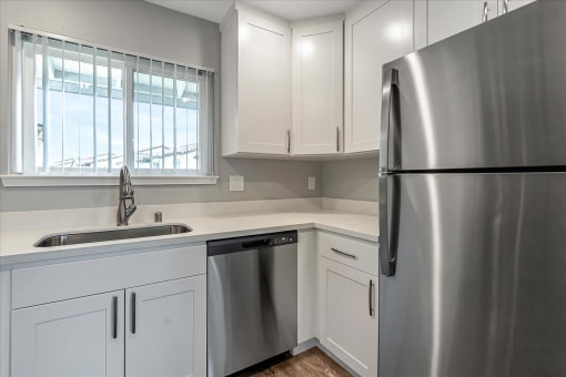 a kitchen with white cabinets and a stainless steel refrigerator
