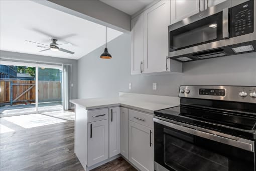a kitchen with white cabinets and black appliances