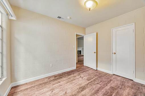 A room with a light brown floor and white walls.