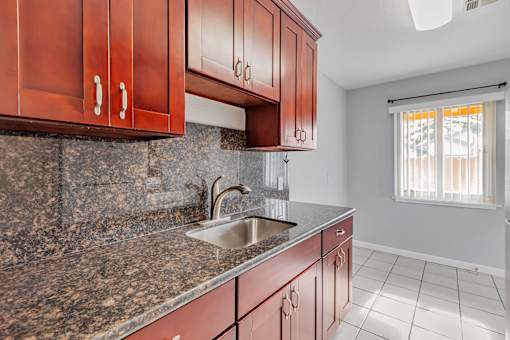 A kitchen with brown cabinets and a granite countertop.