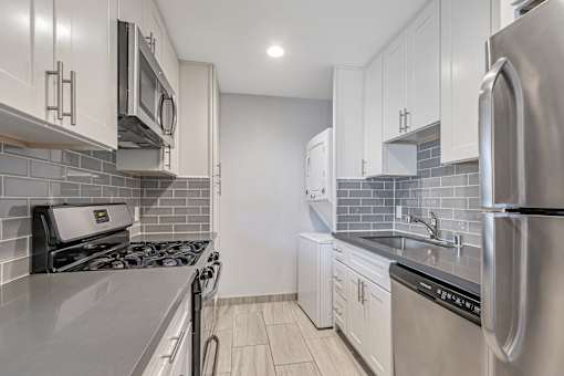A kitchen with a stove, microwave, and refrigerator.