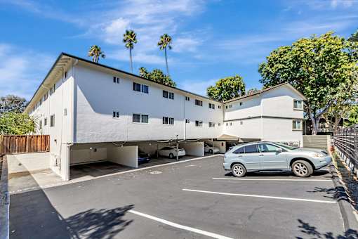 A white building with a car parked in front of it.