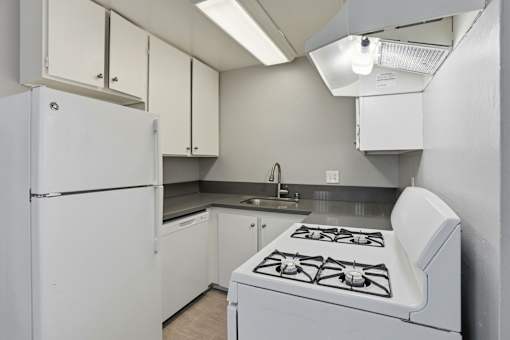 A white kitchen with a stove and cabinets.