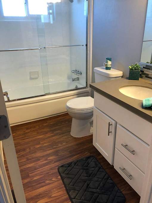 A white toilet sits in a bathroom next to a sink.