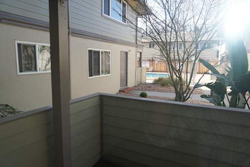 A balcony with a view of a building and trees.