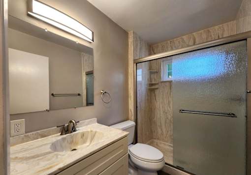 A bathroom with a sink, toilet, and shower.