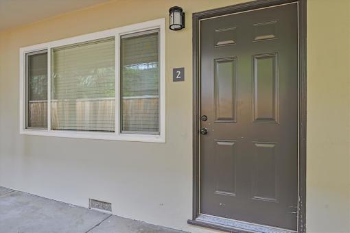A brown door with a number 2 on the wall above it.