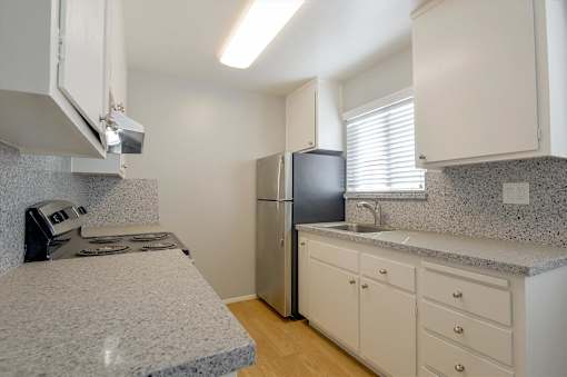 a kitchen with granite counter tops and a stainless steel refrigerator