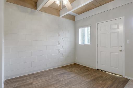 A room with a white door and a window with blinds.