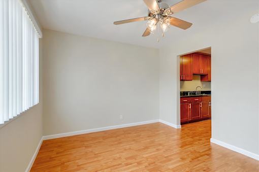 A room with a ceiling fan and wooden floors.