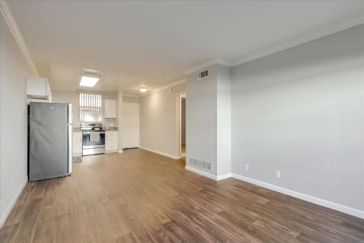 A spacious kitchen with a refrigerator and a dining table.