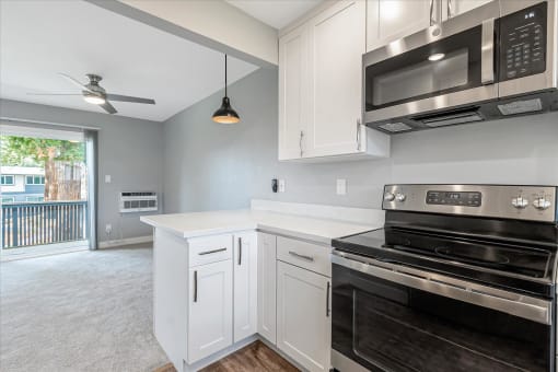 a kitchen with white cabinets and black appliances