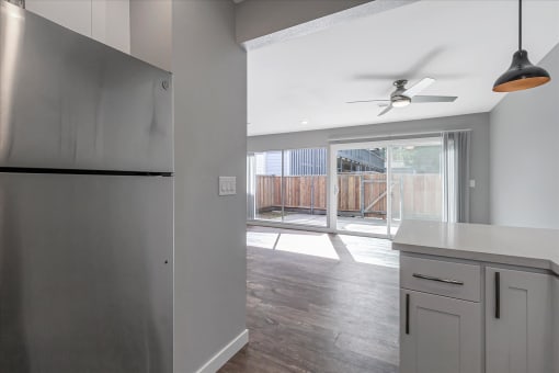 a kitchen with a refrigerator and a ceiling fan